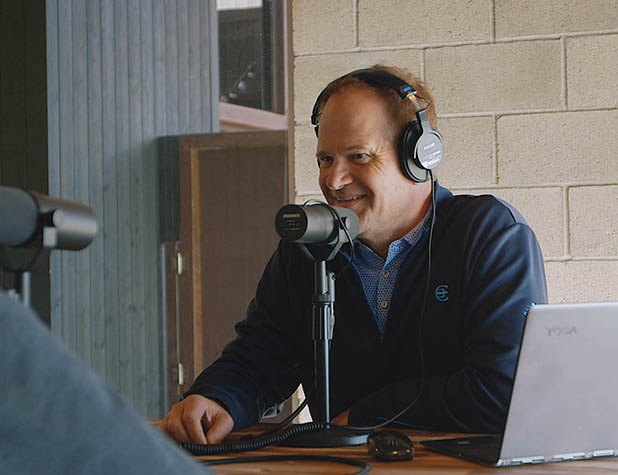 Man sitting at table recording a podcast