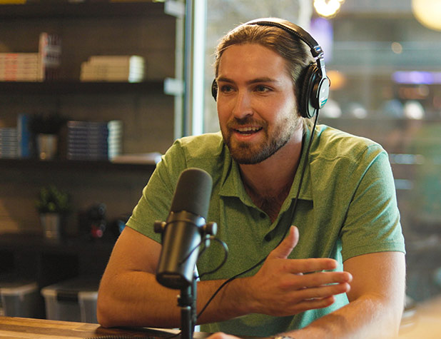 Man sitting at table recording podcast