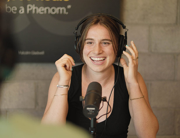 Girl sitting at table recording podcast